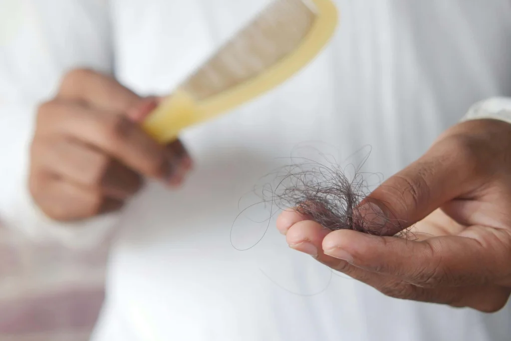 Foto de uma pessoa que viu um tufo de cabelo cair. Como fazer o cabelo crescer? Foto de Towfiqu barbhuiya: https://www.pexels.com/pt-br/foto/mao-segurando-holding-cabelo-9755382/